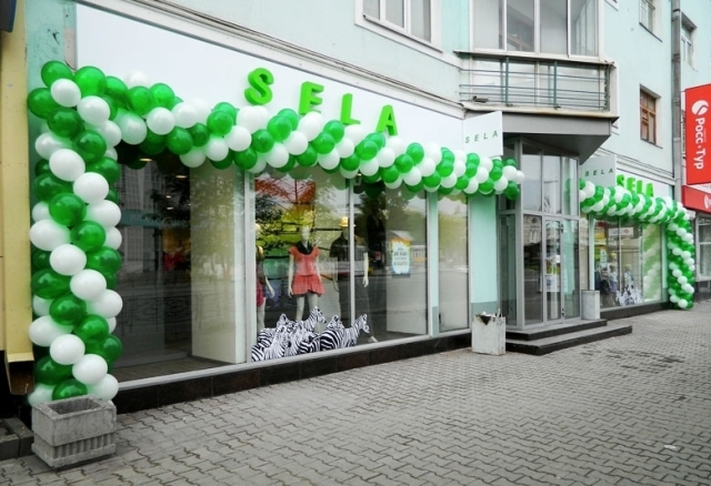 На фото - оформление магазина воздушными шарами в фирменном стиле компании